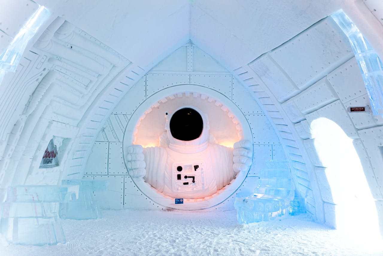 Stunning ice sculpture of an astronaut at Hotel de Glace, capturing winter artistry and futuristic design indoors.